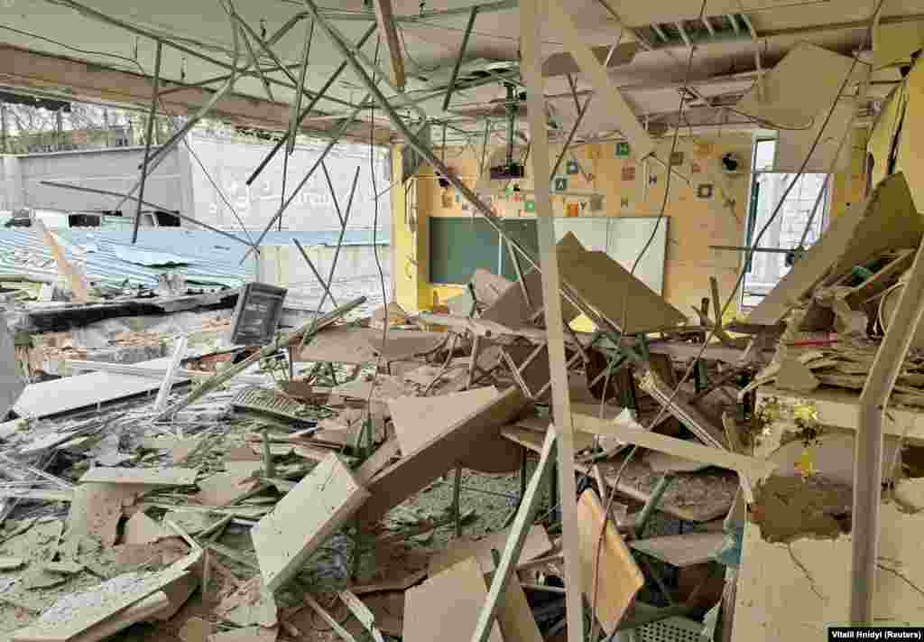 An interior view shows a destroyed classroom.