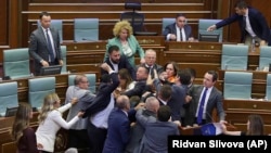The brawl erupted after an opposition lawmaker threw water on Prime Minister Albin Kurti (right) as he spoke before parliament in Pristina on July 13.