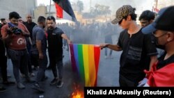 Protestues në Bagdad të Irakut djegin një flamur të komunitetit LGBTI+ gjatë një proteste kundër djegies së një Kurani në Suedi, 22 korrik 2023.