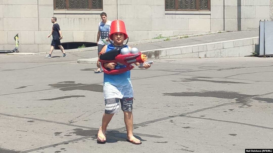 Някои си слагат кофи на главата, за да се предпазят от водните струи и слънцето.