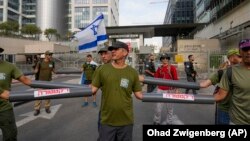 Rezervisti sa rukama u plastičnim cevima u Tel Avivu, 18. jul