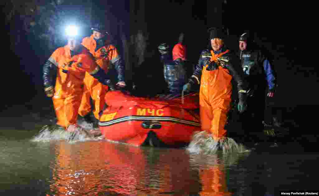 Salvatorii folosesc o barcă pentru a-i evacua pe localnicii de pe o stradă inundată din Evpatoria.