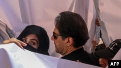 Former Pakistani Prime Minister Imran Khan and his wife, Bushra Khan, arrive at a court hearing in Lahore last year. 