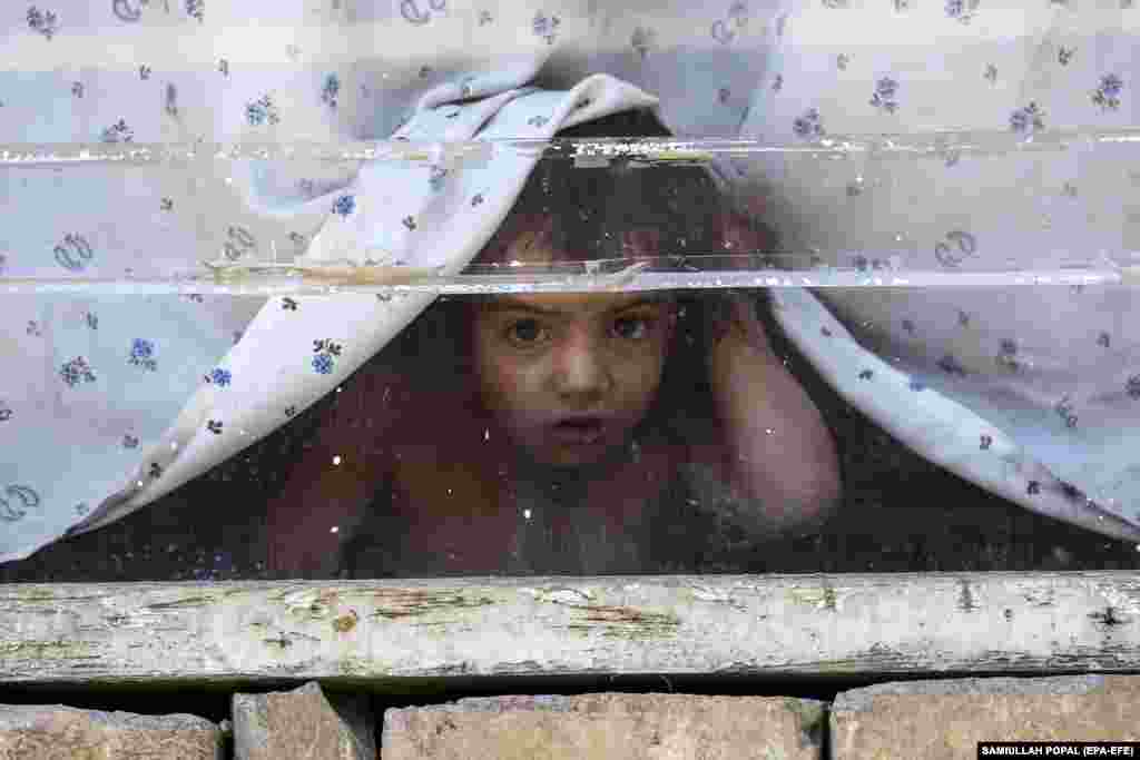 A child peers through a window during a polio vaccination campaign in Kabul.