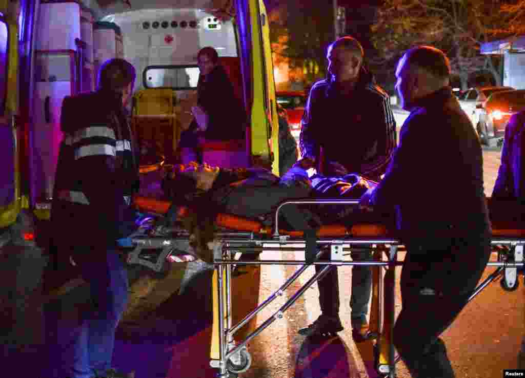 &nbsp;Rescuers evacuate an injured woman from the residential building that was hit by shelling.