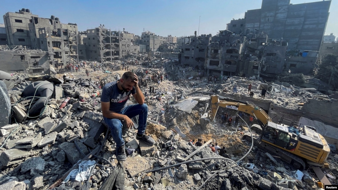 Un bărbat stă pe dărâmături în timp ce palestinienii caută victime la o zi după loviturile israeliene asupra caselor din tabăra de refugiați Jabalia din nordul Fâșiei Gaza, 1 noiembrie 2023.