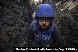 Serhiy Nuzhnenko, a photojournalist with RFE/RL’s Ukrainian Service, in a trench near the village of Pivdenne, near Toretsk in Ukraine’s eastern Donetsk region in April 2022. He and RFE/RL journalist Maryan Kushnir were forced to shelter in a trench because of Russian mortar fire.