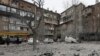 Local residents clear debris following overnight shelling by Russia in Kharkiv on December 8.