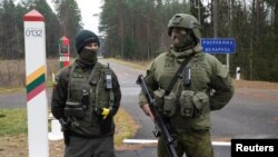 Vojnik litvanske vojske i granični oficir pored beloruske granice u Druskininkaiju, Litvanija, 4. novembra 2021. 