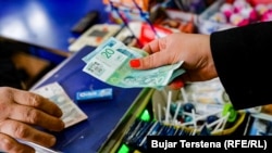 Një person duke paguar me dinarë serbë në një dyqan në Graçanicë më 29 janar 2024.
