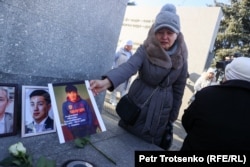 Калимаш Турсынова ставит у мемориала портрет своего сына, погибшего во время Январских событий. Алматы, 5 января 2024 года