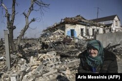 Starija žena stoji ispred uništene kuće nakon bombardovanja u selu Krasiliv, istočno od Kijeva, 20. mart 2022.