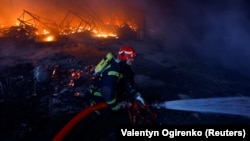 A firefighter works at the site of a warehouse heavily damaged during a Russian missile strike in Kyiv on December 29.