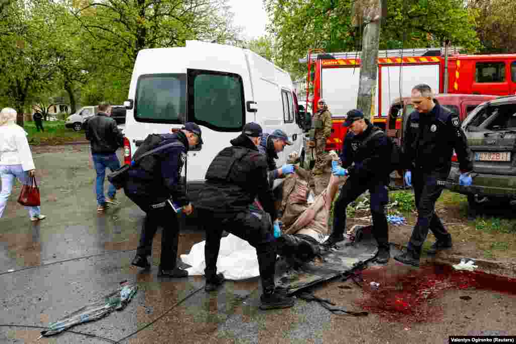 Поліцейські забирають тіло загиблого внаслідок атаки на Чернігів