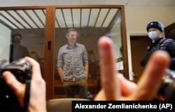 Navalny stands in a cage in a Moscow courtroom on February 20, 2021. His decision to confront Putin’s government directly at the cost of his own freedom became for many a defining and inspirational example.