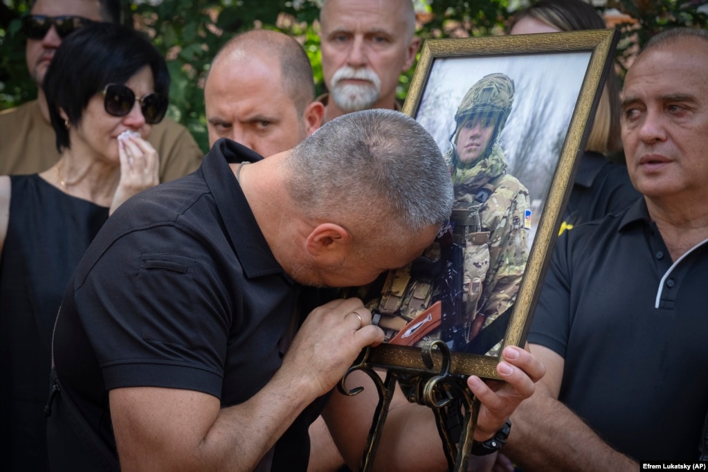 Babai i Ihor Voyevodinit qan teksa përqafon një fotografi të djalit të tij, gjatë një ceremonie mortore në Universitetin e Kievit më 25 gusht. Ihor u vra në një betejë me trupat ruse.
