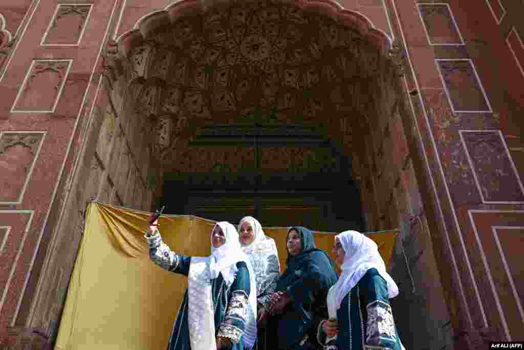 Qadınlar Lahorda (Pakistan) Badşahi camisinde namazdan soñ foto çıqara. Qurban bayramı &ndash; İslâm taqviminiñ eñ büyük bayramlarından biridir