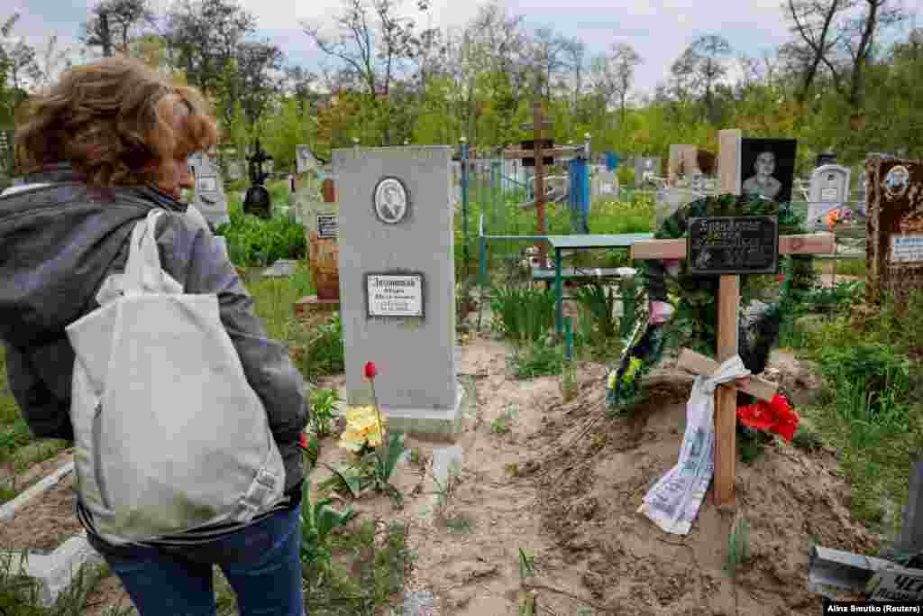 Katerina Vedrenceva, Ljubov Bornyakova nagynénje a dnyiprói temetőben 2023. május 9-én. Tőle jobbra látható Bornyakova sírja, aki feltehetően a férje által elkövetett családon belüli erőszak áldozata volt, idén januárban halt meg. A férfit, Jakov Bornyakovot nem lehetett elérni, hogy nyilatkozzon.&nbsp;A dnyiprói rendőrség szóvivője azt mondta, hogy a nő halálával kapcsolatban büntetőeljárás folyik, de további részletekkel nem kívánt szolgálni