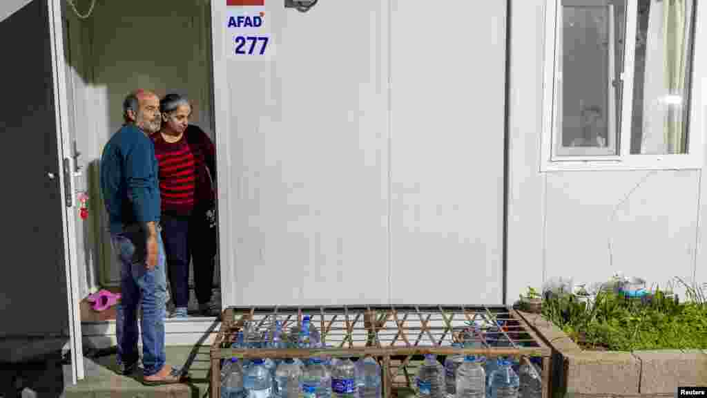 Két túlélő, Ali Riza és Sunay Gazaloglu a földrengés utáni konténerházuk bejáratánál a törökországi Hatayban 2024. január 31-én. A tartomány épületeinek nagy része összeomlott a földrengésben.&nbsp;Hatay lakosainak kétharmada &ndash; akik itt maradtak &ndash; jelenleg konténerházakban él