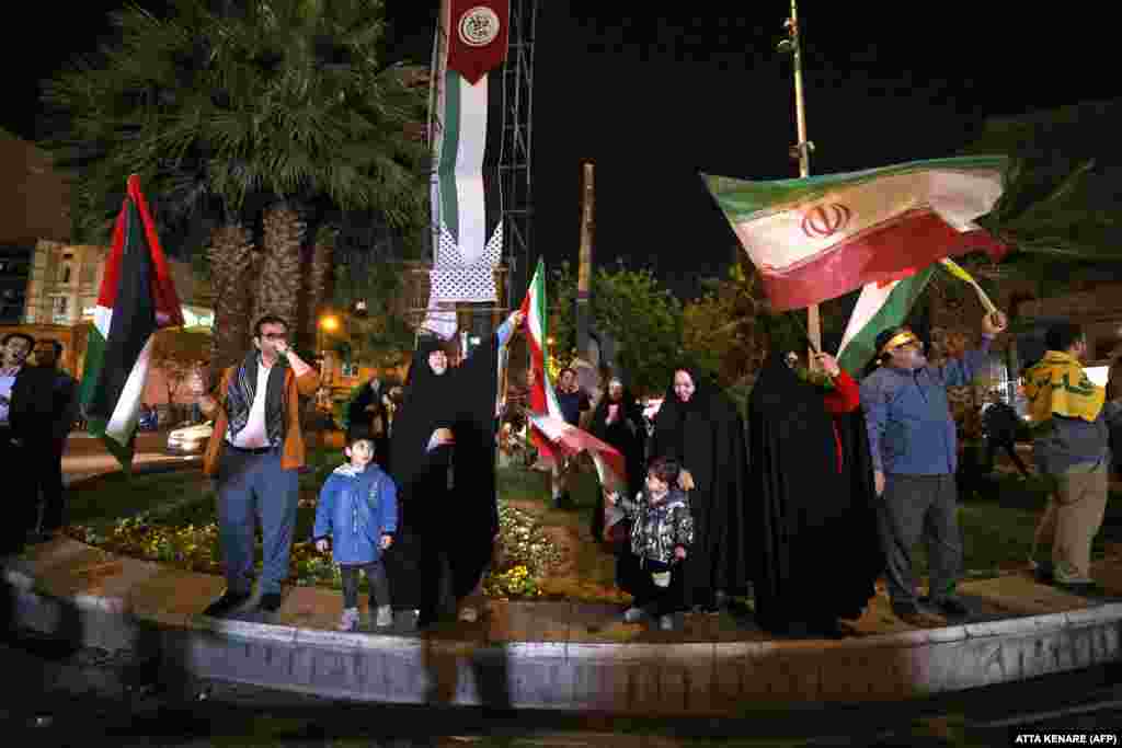 Демонстрантите веат ирански и палестински знамиња додека се собираат на плоштадот Палестина во Техеран рано на 14 април. Израелската војска соопшти дека повеќе од 100 беспилотни летала биле лансирани од Иран, при што безбедносни извори во Ирак и Јордан објавија дека десетици биле видени како летаат, а американските власти велат дека американската војска соборила некои.