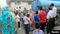 People wait to draw water from a truck in Tabriz on August 4.