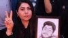 A woman holds a portrait of her son, who was killed during the crackdown on protesters in Iran.