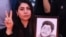 A woman holds a portrait of her son, who was killed during the crackdown on protesters in Iran.