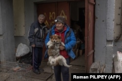 Olena Gubenko își părăsește abia acum casa din regiunea Harkov, împreună cu peste 100 de câini rămași fără stăpân de care a avut grijă. O ajută o echipă de voluntari.