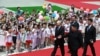 Vladimir Putin i Kim Džong Un hodaju crvenim tepihom dok ih djeca pozdravljaju mašući ruskim zastavama, Pjongjang 19. juni 2024.