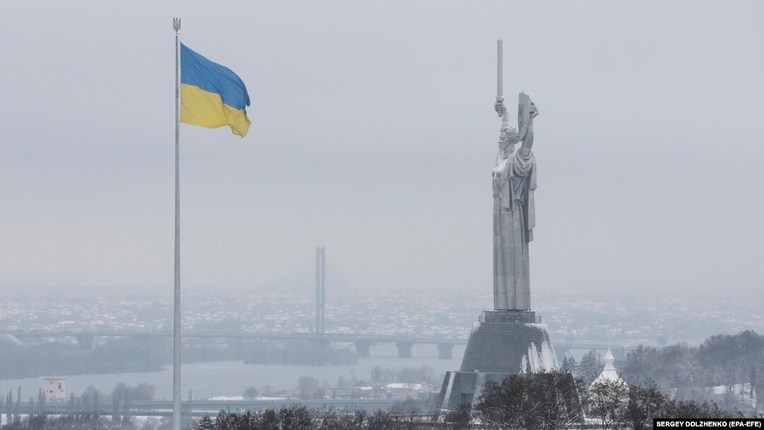 The Ukrainian national flag flies next to the Motherland Monument during the first snowfall of winter in Kyiv on November 22.