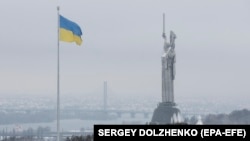 The Ukrainian national flag flies next to the Motherland Monument during the first snowfall of winter in Kyiv on November 22. 