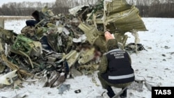 An investigator examines debris at the crash site of an Ilyushin Il-76 aircraft, which came down near the western Russian city of Belgorod on January 24. 