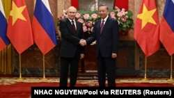 Președintele vietnamez To Lam dă mâna cu președintele rus Vladimir Putin (dreapta) la Hanoi pe 20 iunie 2024.