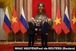 Președintele Rusiei, Vladimir Putin, și președintele Vietnamului, To Lam, își strâng mâinile la Palatul Prezidențial din Hanoi, Vietnam, pe 20 iunie.