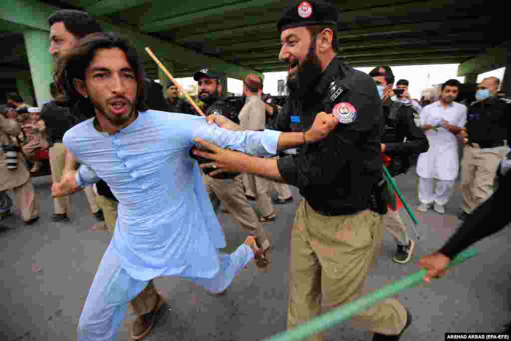 Police detain a supporter of former Pakistani Prime Minister and opposition leader Imran Khan at a demonstration in Peshawar after Khan was arrested following court orders that sentenced him to three years in prison on August 5.