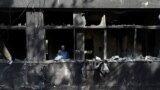 A man uses his mobile phone to take pictures inside the Radio Pakistan office building after it was set afire by supporters of Pakistan's former Prime Minister Imran Khan during a protest against his arrest in Peshawar on May 10.