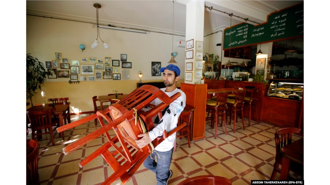An Afghan migrant working in his cafe in Tehran (file photo)