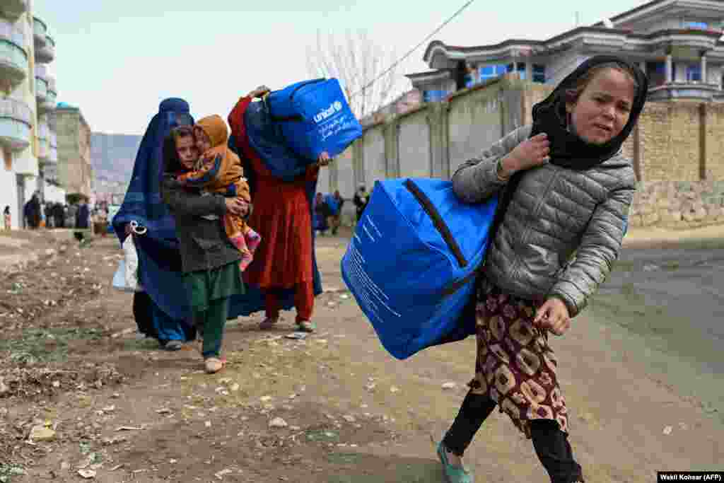 Afghans carry winter kits from UNICEF at Fayzabad in Badakhshan Province.