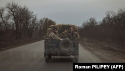 Українські військовослужбовці їдуть біля Часового Яру, 3 квітня 2024 року
