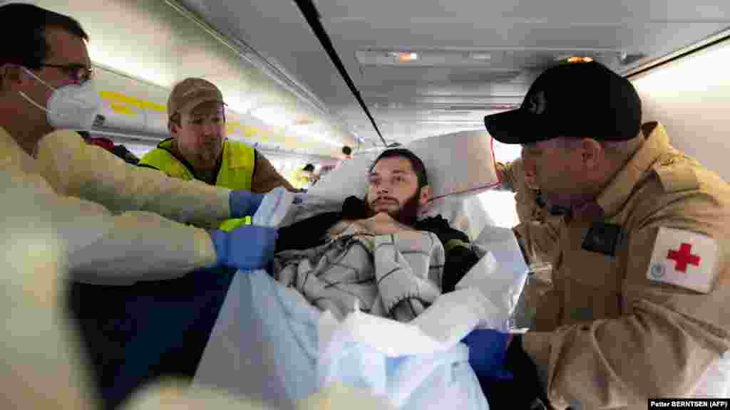 Медицински персонал се подготвя да премести ранения Владислав Шахов след пристигането на самолета в Берлин.