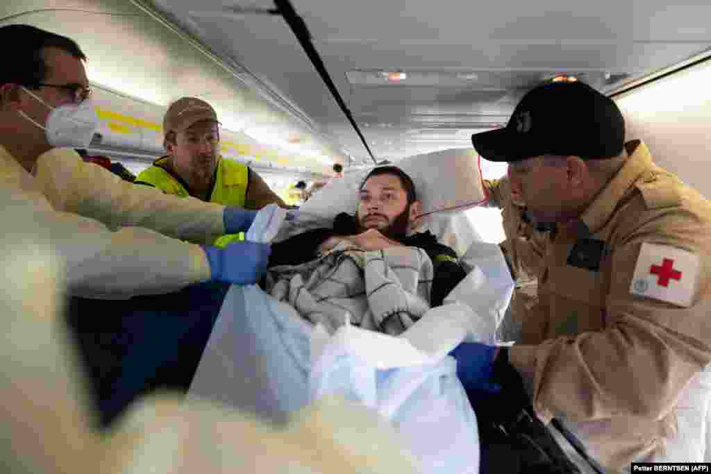Medical staff prepare to move Vladyslav Shakhov after the plane&#39;s arrival at Berlin Brandenburg Airport.