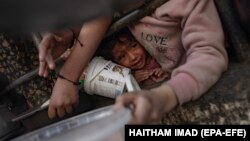 Reakcija djeteta dok interno raseljeni Palestinci čekaju hranu koju donira humanitarna grupa, četvrtog dana svetog mjeseca ramazana u Rafahu, na jugu Pojasa Gaze, 14. marta 2024.