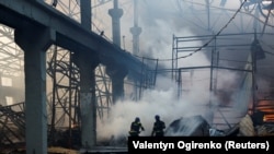 Рятувальники гасять пожежу на складі, сильно пошкодженому під час російського ракетного удару, Київ, 29 грудня 2023 року