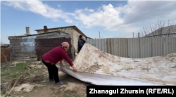 Жители Каратала сушат линолеум на улице. Село Каратал, 13 апреля 2024 года