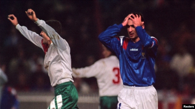 Френският нападател Ерик Кантона се държи за главата си с недоумение, а българският централен нападател Любослав Пенев показва радостта си, след като България елиминира Франция с 2:1 в квалификационния мач за Световната купа, 17 ноември, 1993 г.