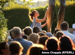 Mlada žena briše tekućinu koja curi s kipa Isusa u središtu Međugorja, dok drugi hodočasnici čekaju svoj red 3. avgusta 2023. Kaže se da tekućina ima isti sastav kao ljudske suze.