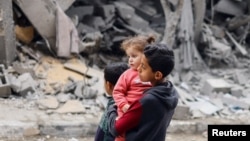 Palestinska djeca nedaleko od srušene kuće u Rafi, Pojas Gaze, 24. mart 2024.