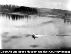Egy Douglas World Cruiser kétfedelű repülőgép száll fel a seattle-i Washington-tóról, hogy megkezdje 175 napos, világ körüli útját