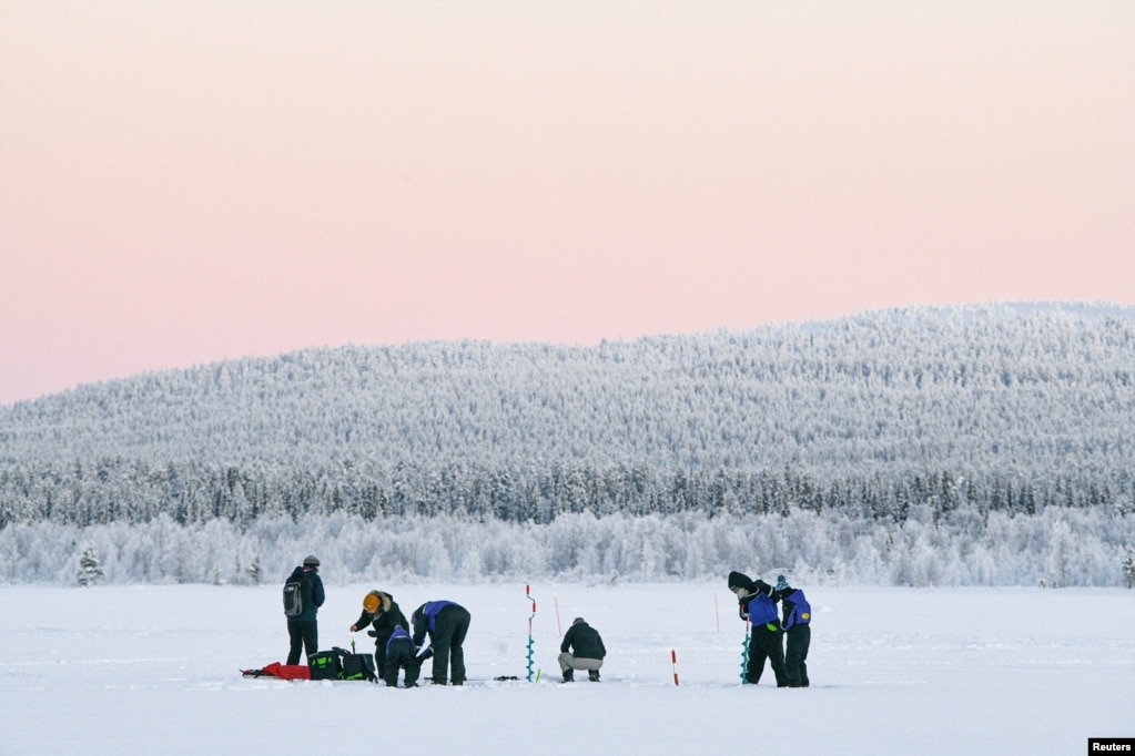 Njerëzit duke zënë peshq nën akull  në qytetin e Akaslompolos, në Kolari, Finlandë, 4 janar 2024.