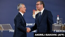NATO Secretary-General Jens Stoltenberg shakes hands with Serbian President Aleksandar Vucic during a press conference following their meeting in Belgrade on November 21.